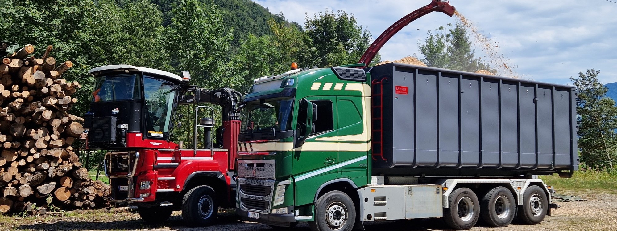 JP Mennel Transporte gruener LKW Muldenkipper beim Beladen mit Hackschnitzel