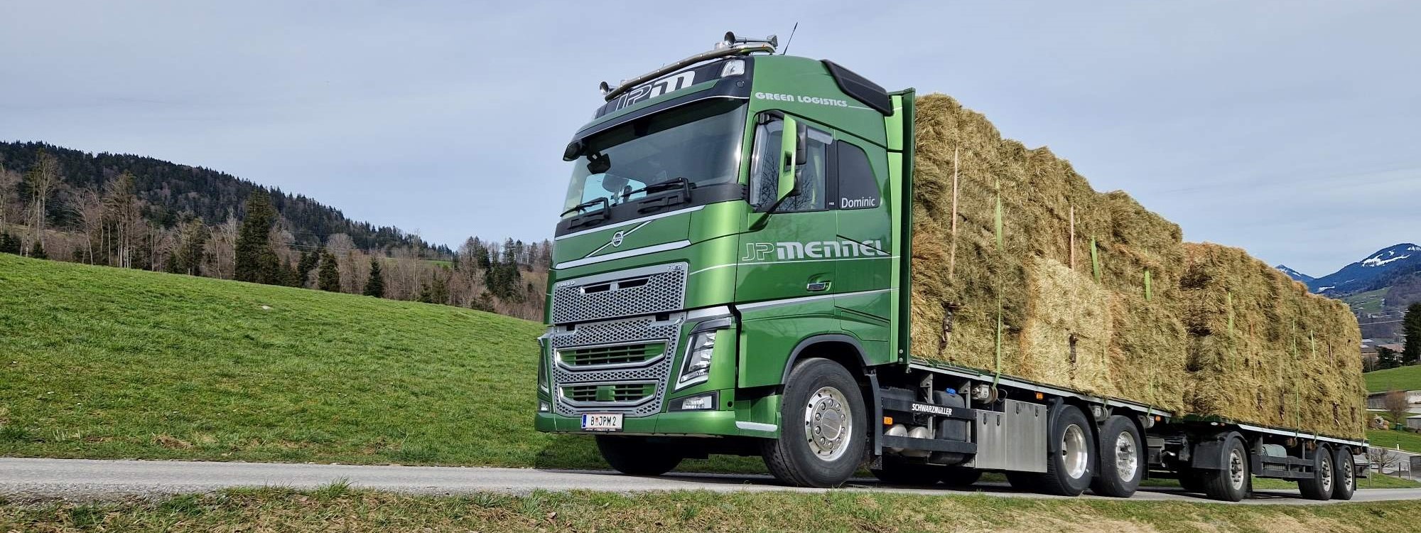 JP Mennel Transporte gruener Haengerzug mit Heuladung