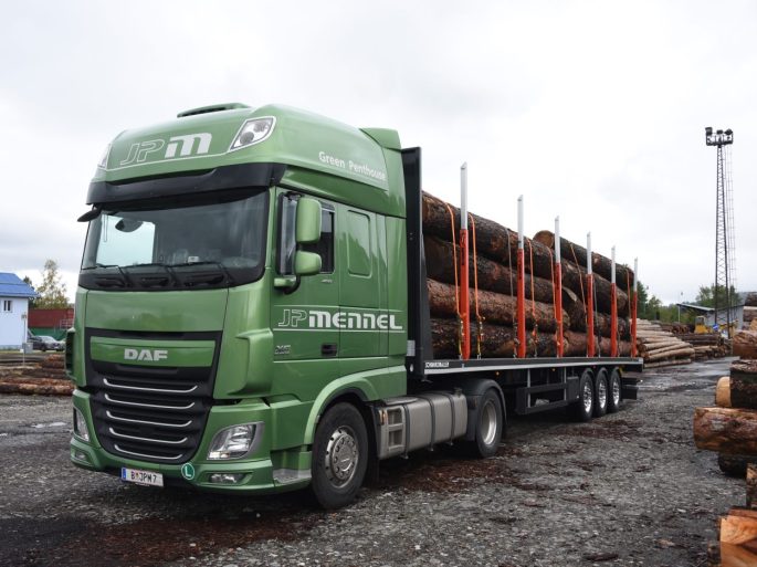 JP Mennel Transporte gruener LKW mit Rundholzladung